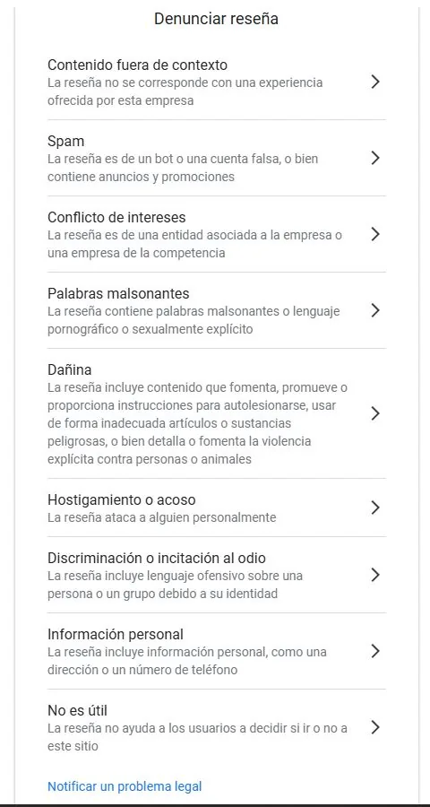 Panel 'Denunciar reseña' de Google Business Profile con los motivos: contenido fuera de contexto, spam, conflicto de intereses, palabras malsonantes, contenido dañino, acoso, incitación al odio, información personal y no útil